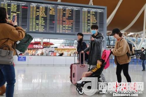 旅客帶著孩子前往辦票柜臺辦理登機手續(xù)。　殷立勤 攝