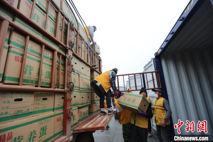 圖為鐵路裝卸作業(yè)人員正在將云南特色農產品裝入集裝箱?！詈?攝
