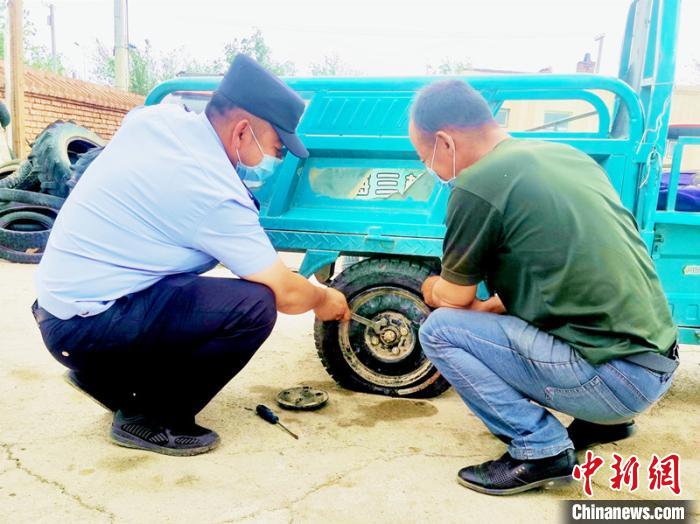 賽旦與民警共同維修三輪摩托車?！∫懒窘?攝