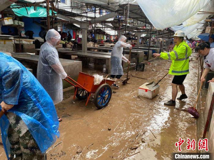 圖為7月26日，暴雨引發(fā)的洪水過境后，重慶萬州區(qū)分水鎮(zhèn)政府干部職工及志愿者清掃淤泥和垃圾?！　≈貞c萬州區(qū)委宣傳部供圖 攝