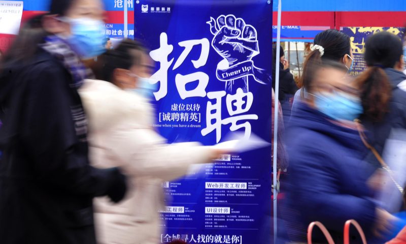 求職者從一家招聘企業(yè)的廣告牌前走過(guò)。新華社發(fā)（苑立偉 攝）