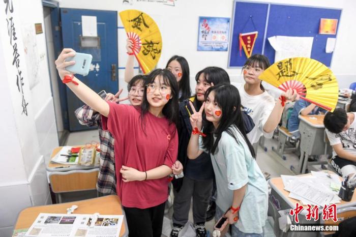 資料圖：6月6日，2021年高考前夕，湖南長沙同升湖實(shí)驗(yàn)學(xué)校高三年級，考生們在教室內(nèi)合影。 楊華峰 攝