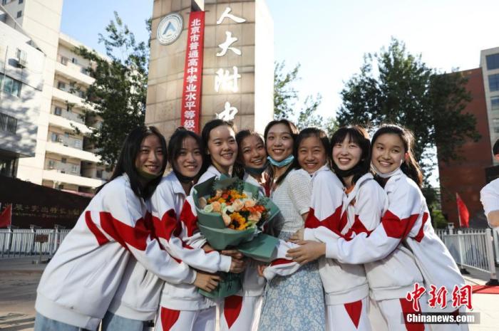 資料圖：6月10日，在北京人大附中高考考點(diǎn)外，考生們相擁拍照留念。當(dāng)日，北京市2021年高考結(jié)束?！?<a target='_blank'  data-cke-saved- ><p  align=